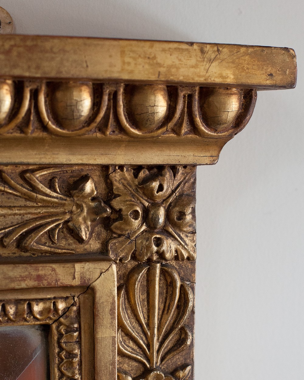A large 19th-century rectangular giltwood overmantel mirror featuring a ribbon bow knot crest, carved bead moulding, and a flared base. View II