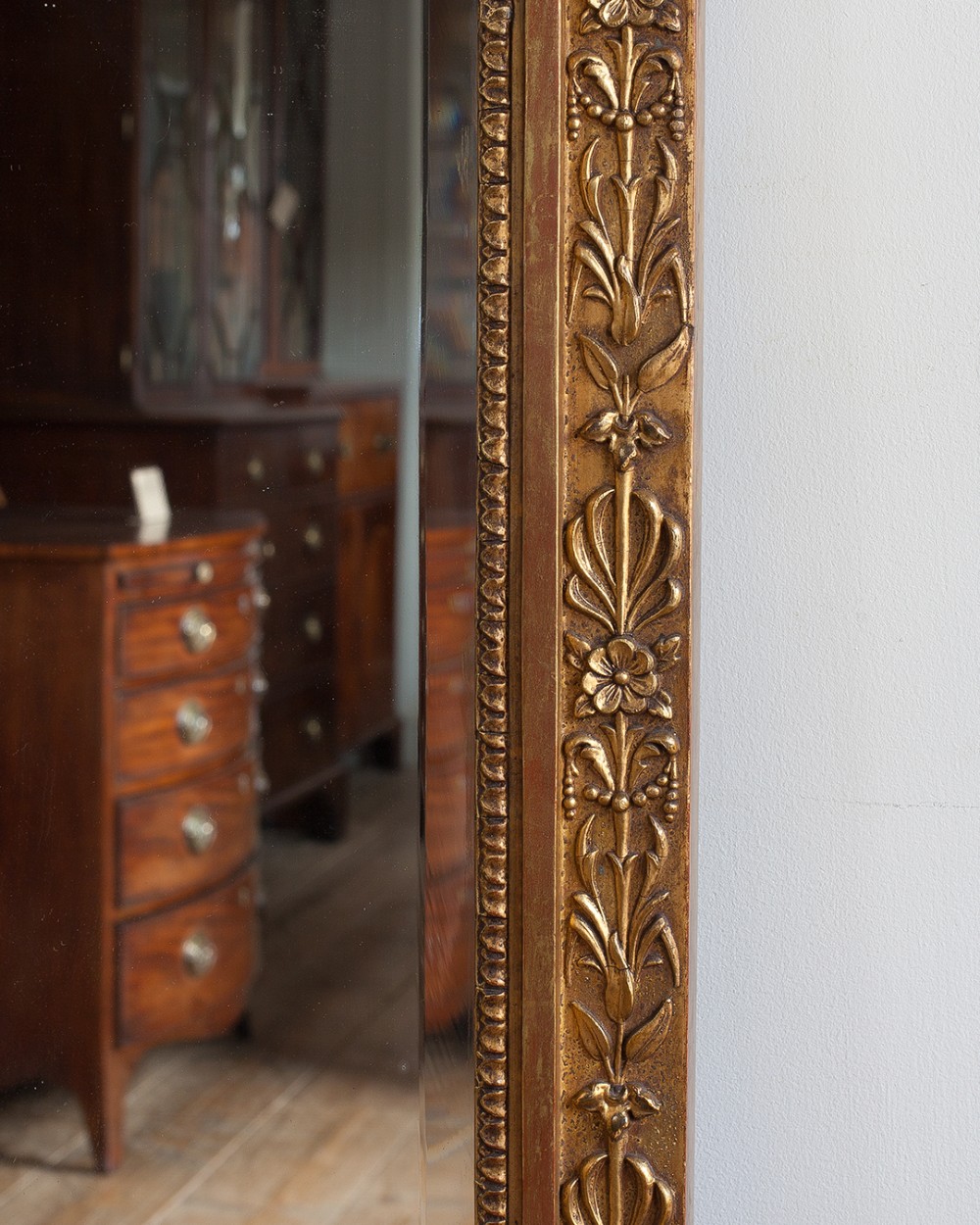 A large 19th-century rectangular giltwood overmantel mirror featuring a ribbon bow knot crest, carved bead moulding, and a flared base. View V