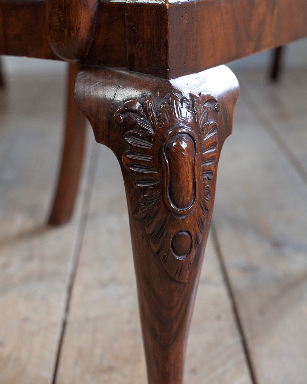 A set of twelve 18th-century carved walnut dining chairs featuring vase-shaped splats, cabriole legs, and floral needlepoint seats. View IV