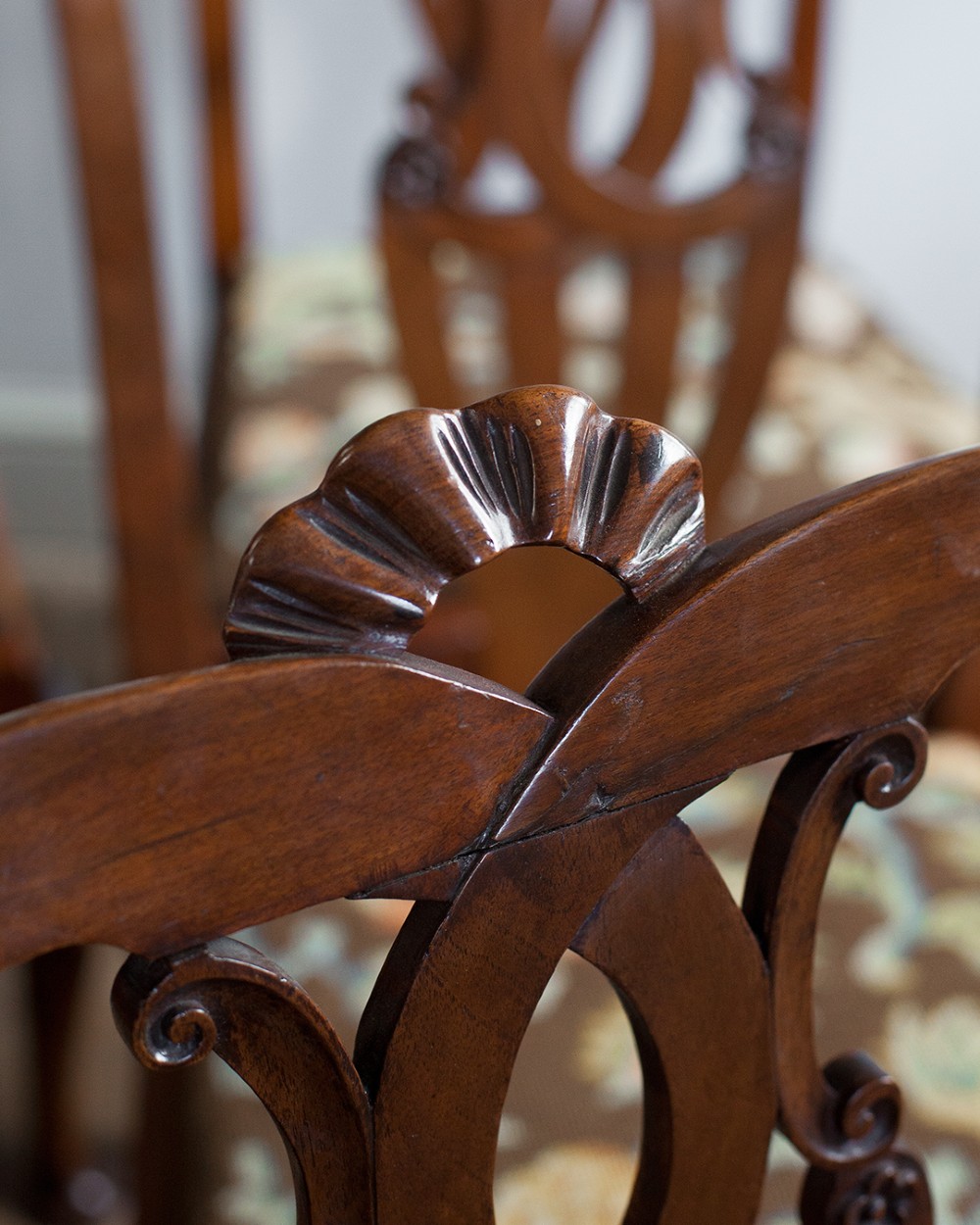 A set of twelve 18th-century carved walnut dining chairs featuring vase-shaped splats, cabriole legs, and floral needlepoint seats. View VII