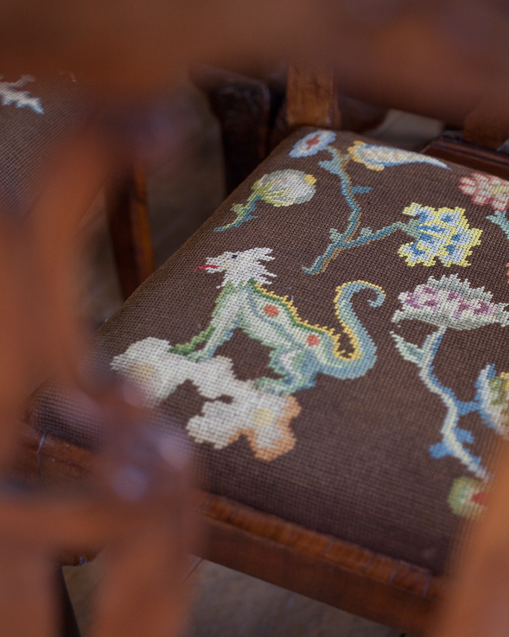 A set of twelve 18th-century carved walnut dining chairs featuring vase-shaped splats, cabriole legs, and floral needlepoint seats. View VIII
