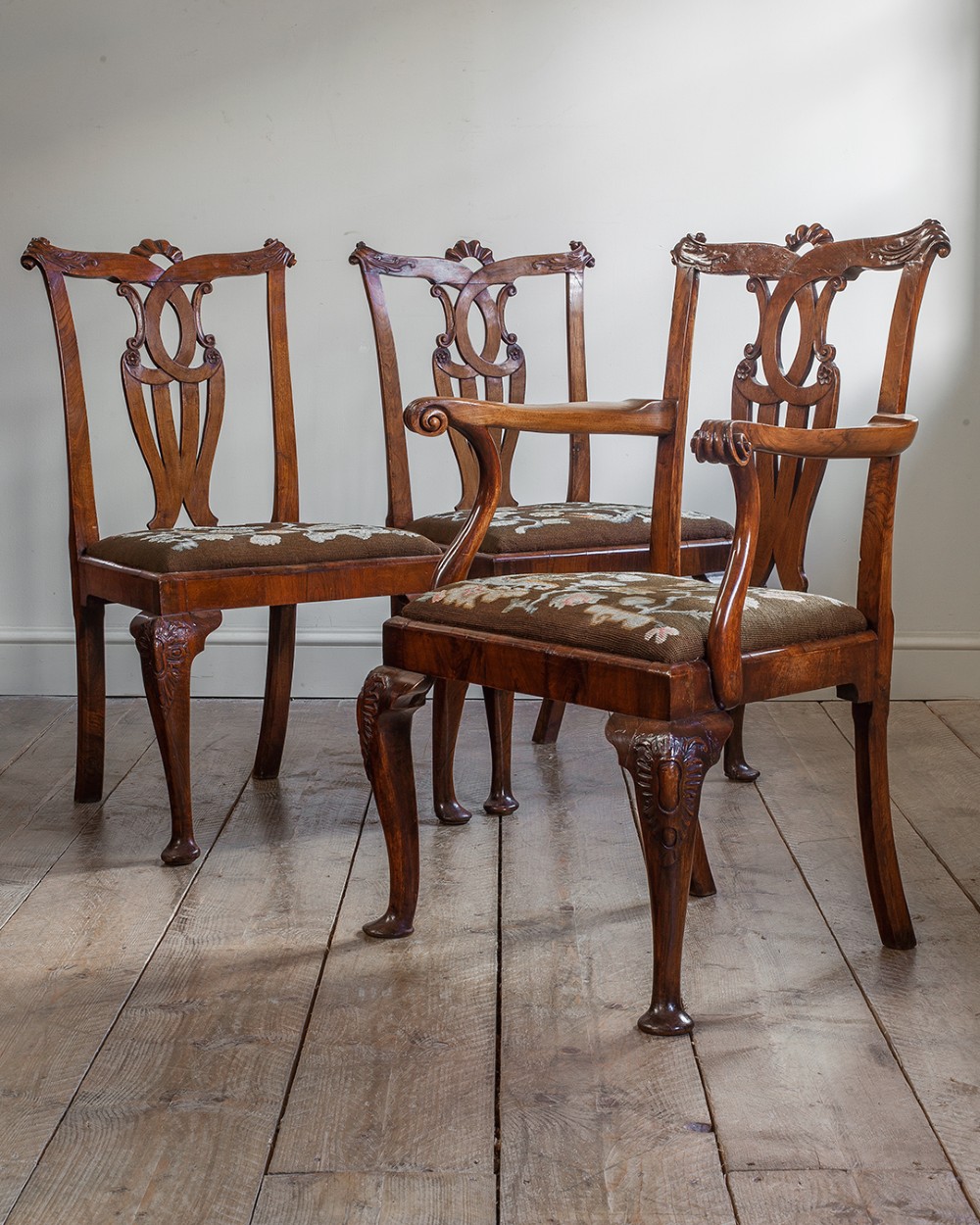 A set of twelve 18th-century carved walnut dining chairs featuring vase-shaped splats, cabriole legs, and floral needlepoint seats. View XI