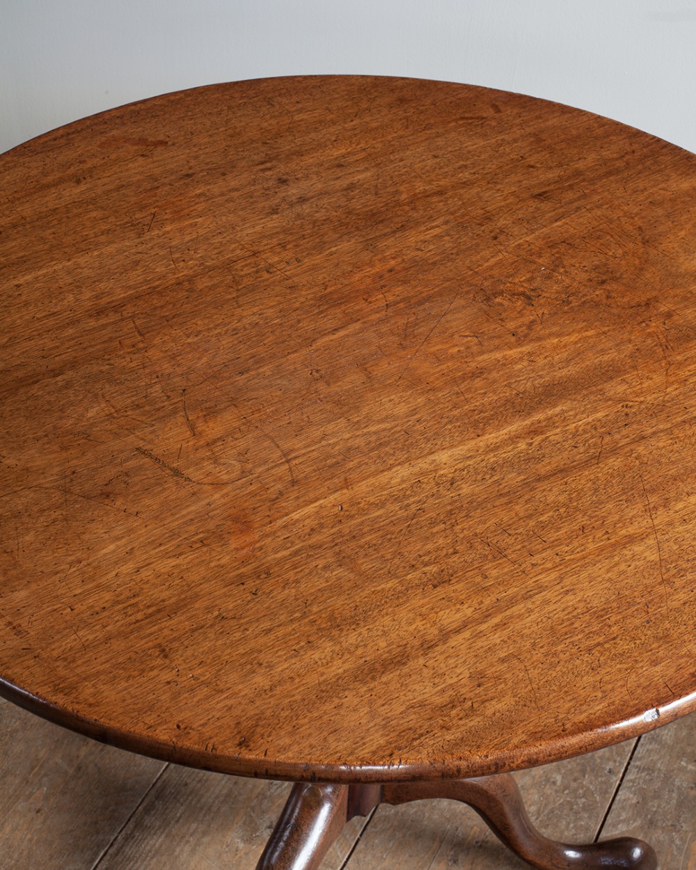 A George III mahogany tripod table featuring a circular top supported by a turned pedestal column with spiral carving and three cabriole legs. View V