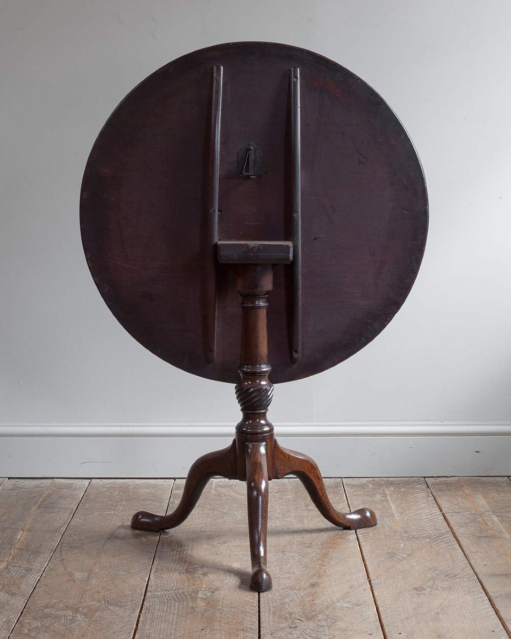 A George III mahogany tripod table featuring a circular top supported by a turned pedestal column with spiral carving and three cabriole legs. View VIII