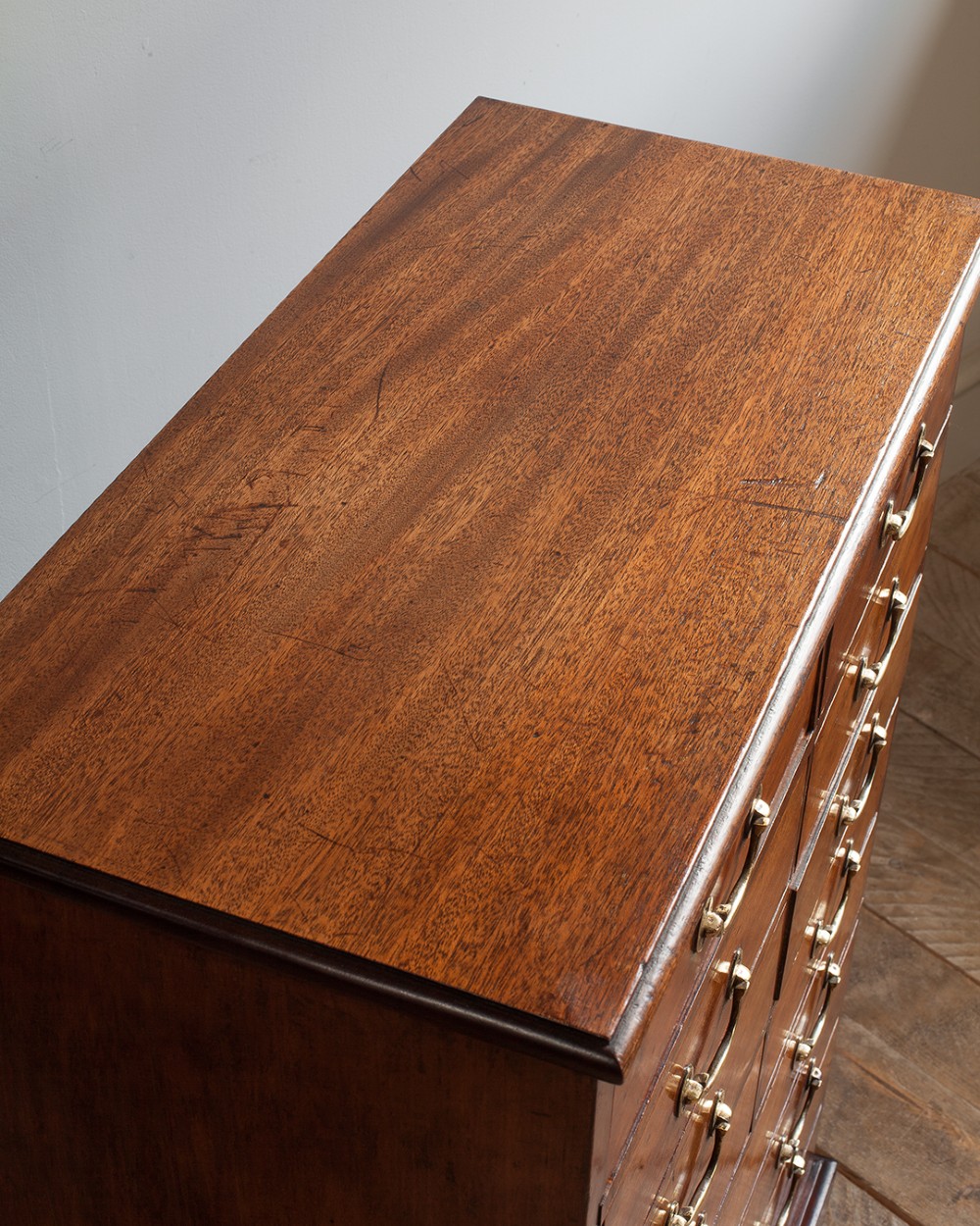 A tall 19th-century mahogany bank of drawers featuring eight tiers of small and wide drawers with brass handles, resting on a solid plinth base. View IV