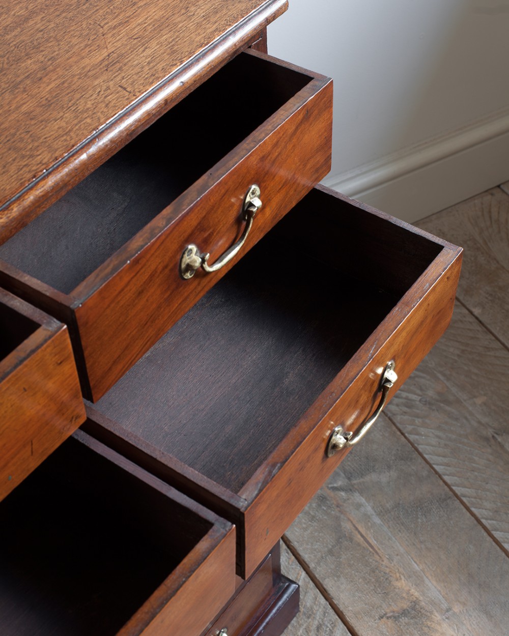 A tall 19th-century mahogany bank of drawers featuring eight tiers of small and wide drawers with brass handles, resting on a solid plinth base. View VII