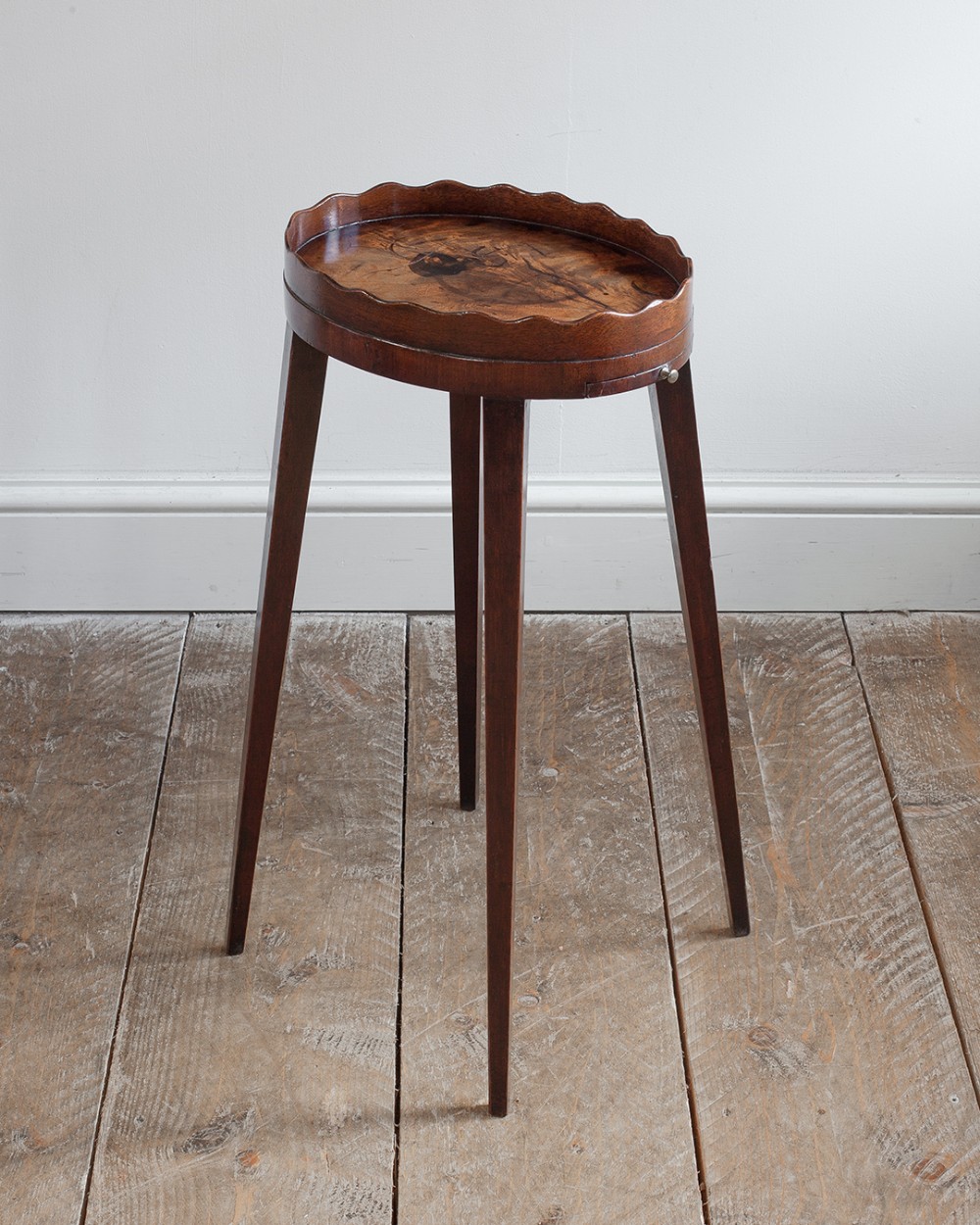 A George III mahogany oval urn stand with a scalloped gallery rim, a pull-out slide with a small brass handle, and four tapered square legs.