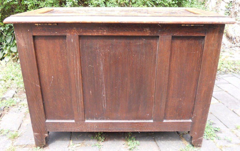 A rectangular Victorian carved oak blanket chest featuring a central carved face mask surrounded by geometric panel mouldings. View XIII
