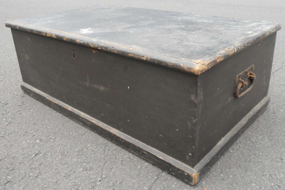 A rectangular black painted Victorian pine travelling box with a keyhole on the front panel and a metal plaque on the lid. View III