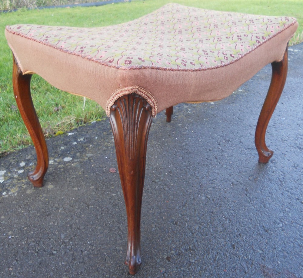 A Victorian walnut dressing stool featuring a concave seat with geometric tapestry fabric supported by four carved cabriole legs. View II