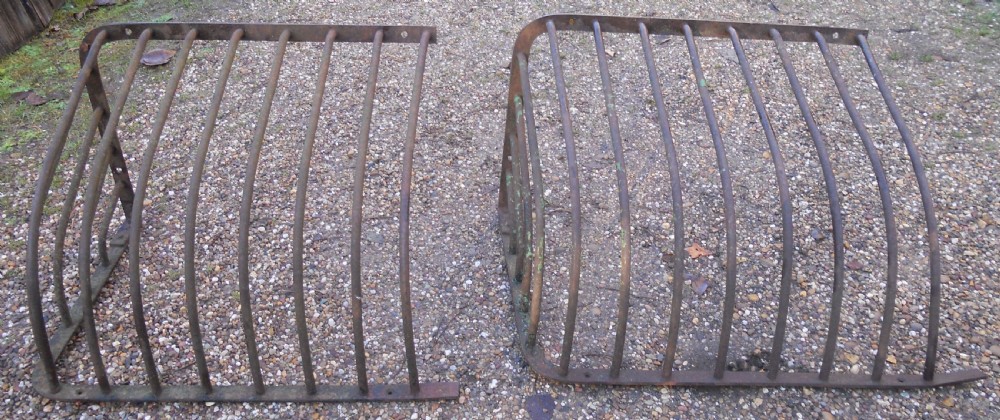 A pair of Victorian dark wrought iron curved hay racks featuring vertical metal bars and mounting plates. View IV