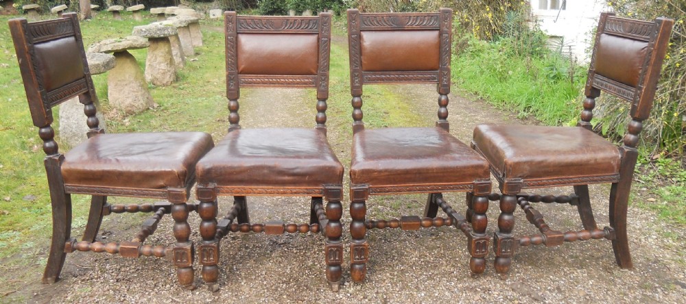 A set of four antique dark oak dining chairs featuring carved backrests, turned legs, and brown leather upholstered seats. View VIII