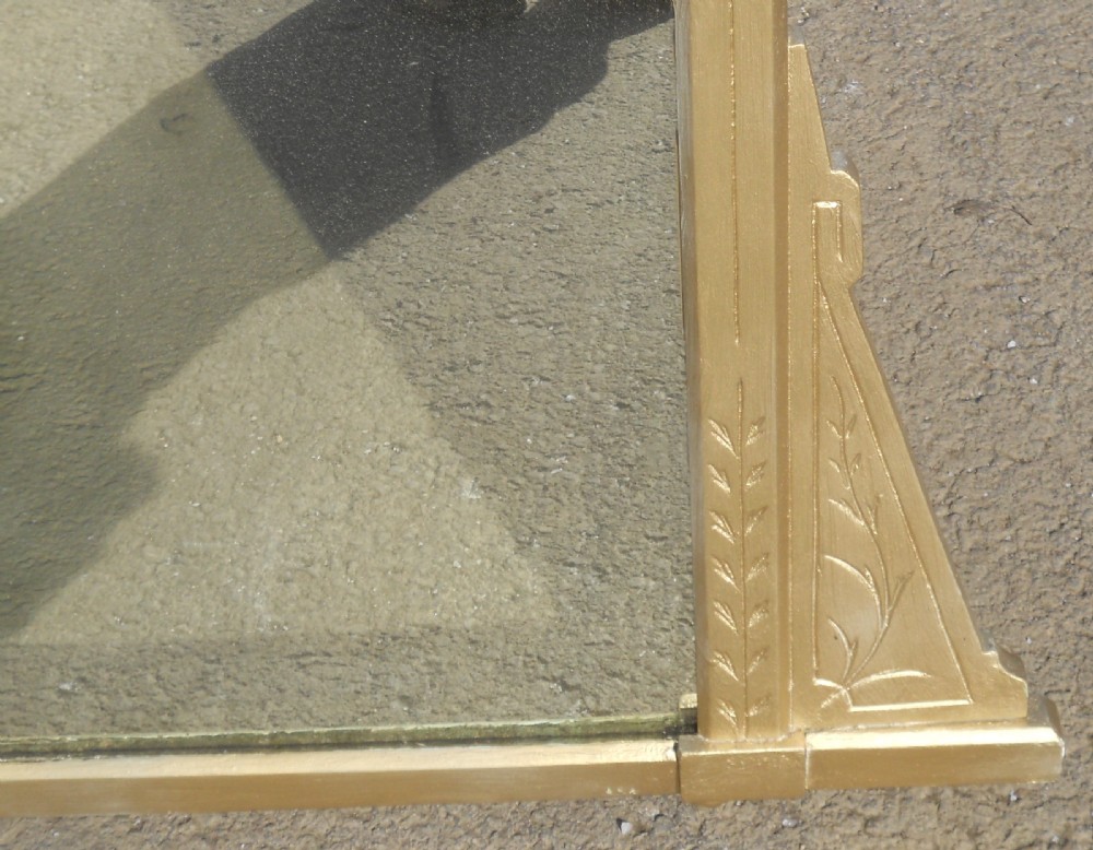 An Aesthetic Movement giltwood overmantel mirror featuring incised botanical carving, linear details, side bracket supports, and a pediment crest. View V