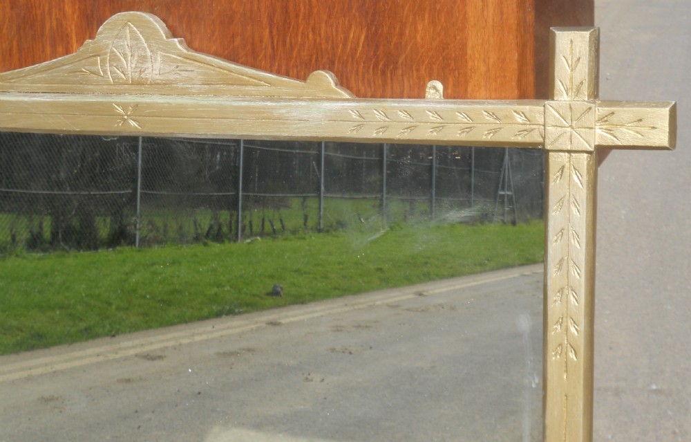 An Aesthetic Movement giltwood overmantel mirror featuring incised botanical carving, linear details, side bracket supports, and a pediment crest. View VI