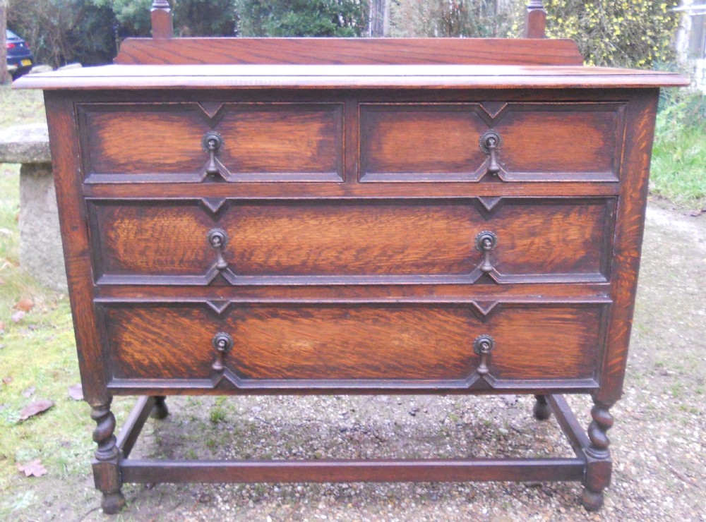 An antique dark oak dressing table with an arched swivel mirror, barley twist supports, and three drawers featuring geometric moulding. View VI