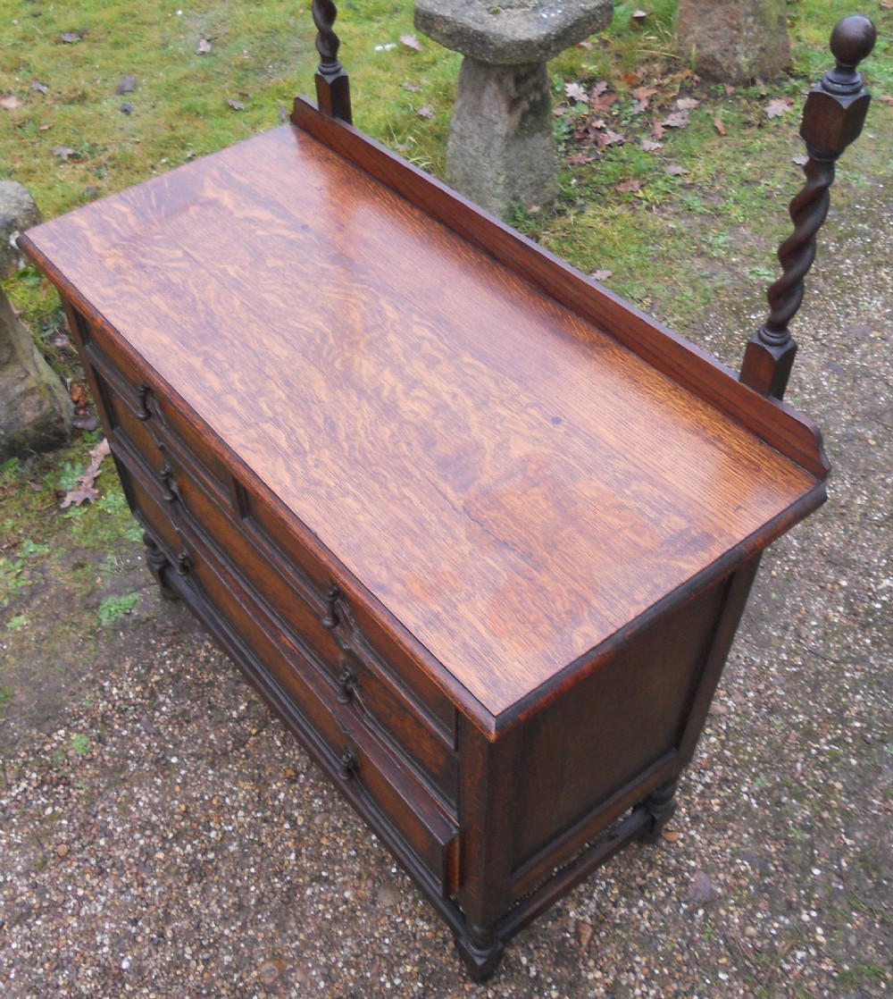 An antique dark oak dressing table with an arched swivel mirror, barley twist supports, and three drawers featuring geometric moulding. View VIII