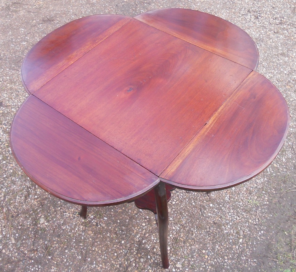 An Edwardian mahogany drop-leaf centre table with cabriole legs, two hinged side flaps, and a scalloped lower tier. View V