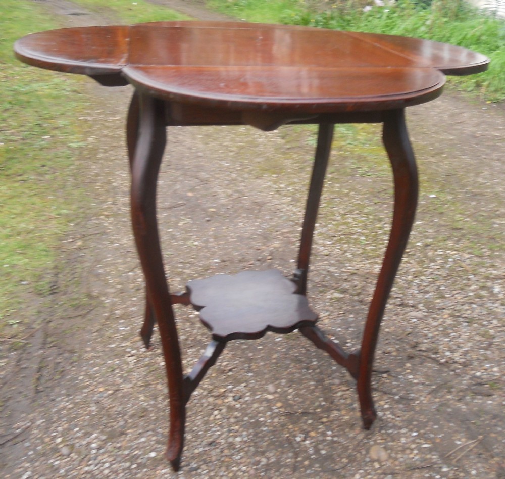 An Edwardian mahogany drop-leaf centre table with cabriole legs, two hinged side flaps, and a scalloped lower tier. View VIII