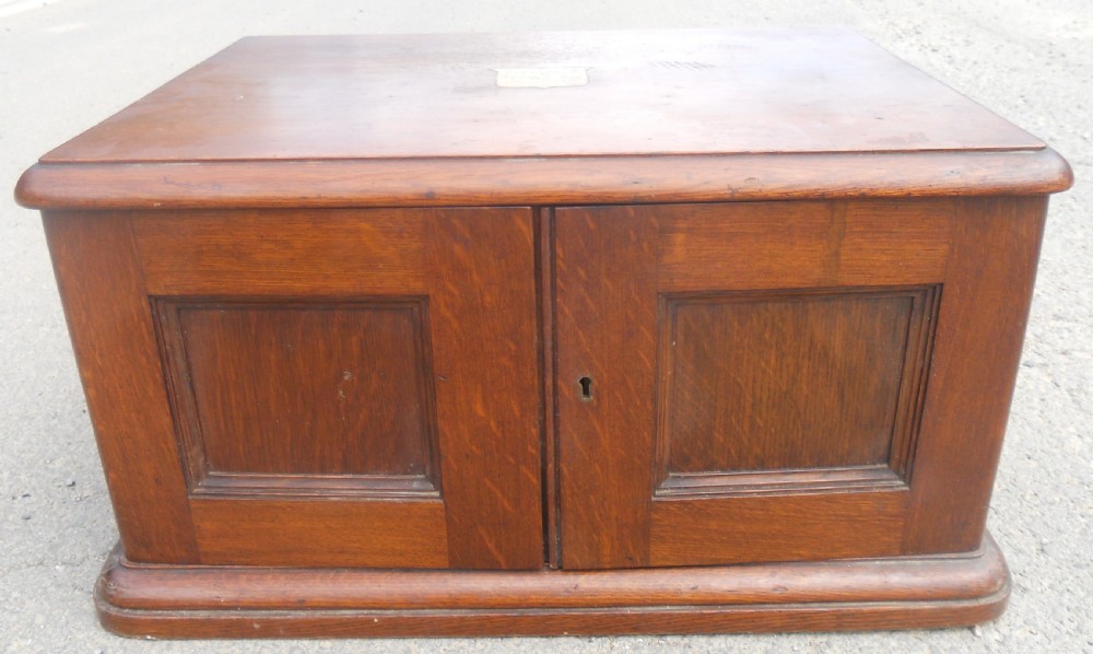 A large Victorian mahogany cutlery box featuring twin front panel doors, brass side handles, and a top brass plaque. View V