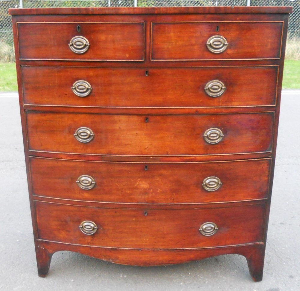 A Georgian mahogany bowfront chest of drawers featuring two short drawers over three long graduated drawers with brass oval handles.