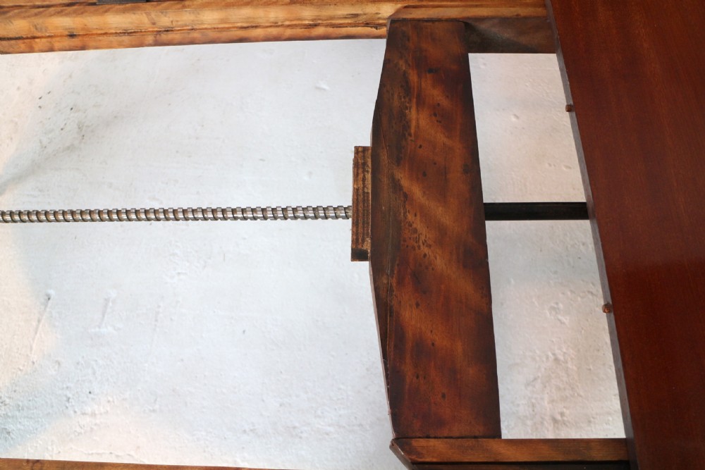 An extended Victorian Cuban mahogany dining table with rounded ends, turned legs, and brass castors. View XII