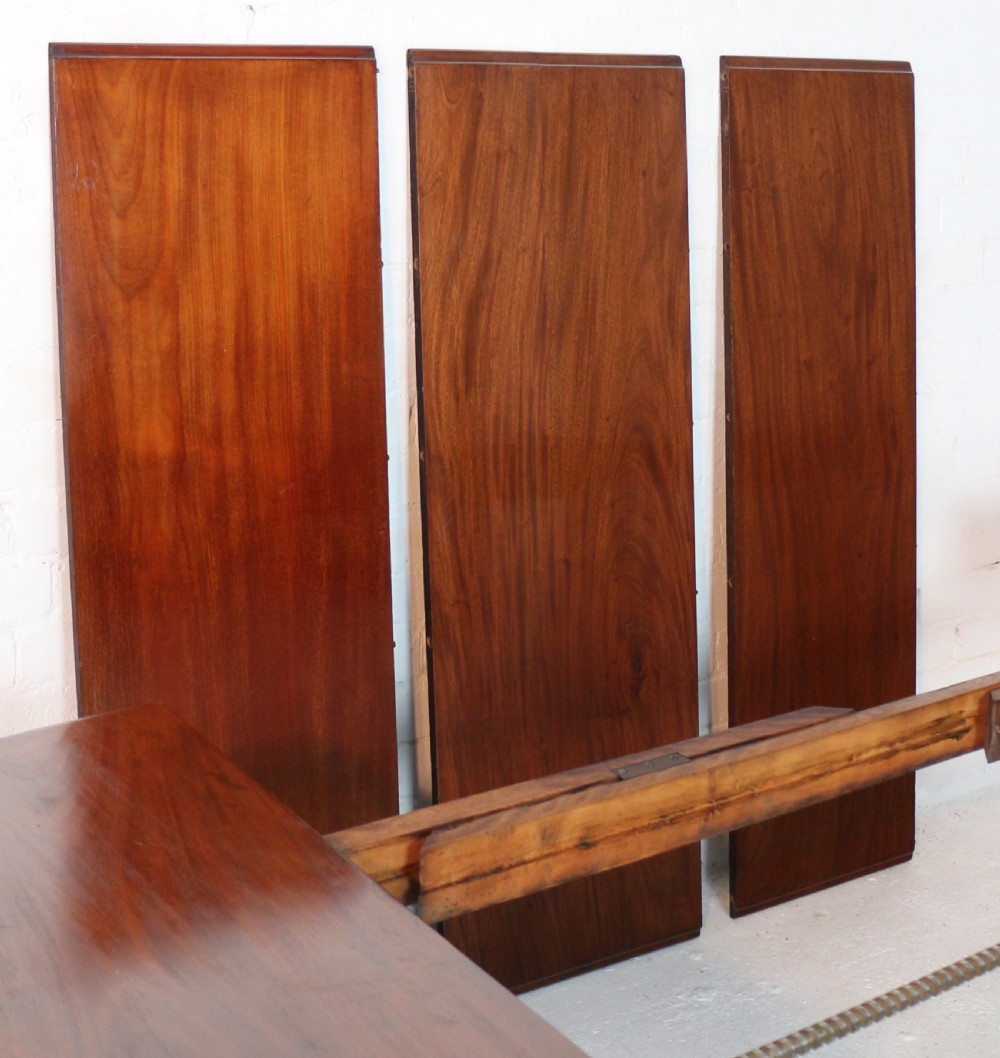 An extended Victorian Cuban mahogany dining table with rounded ends, turned legs, and brass castors. View XXIV