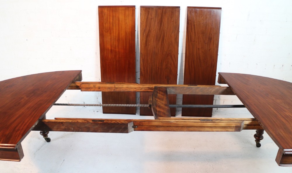 An extended Victorian Cuban mahogany dining table with rounded ends, turned legs, and brass castors. View XXVII