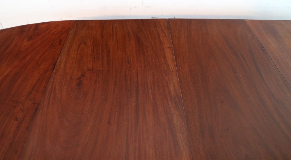 An extended Victorian Cuban mahogany dining table with rounded ends, turned legs, and brass castors. View XXVIII