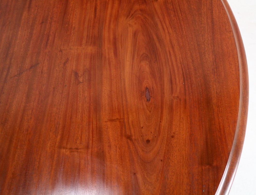 An extended Victorian Cuban mahogany dining table with rounded ends, turned legs, and brass castors. View XXX