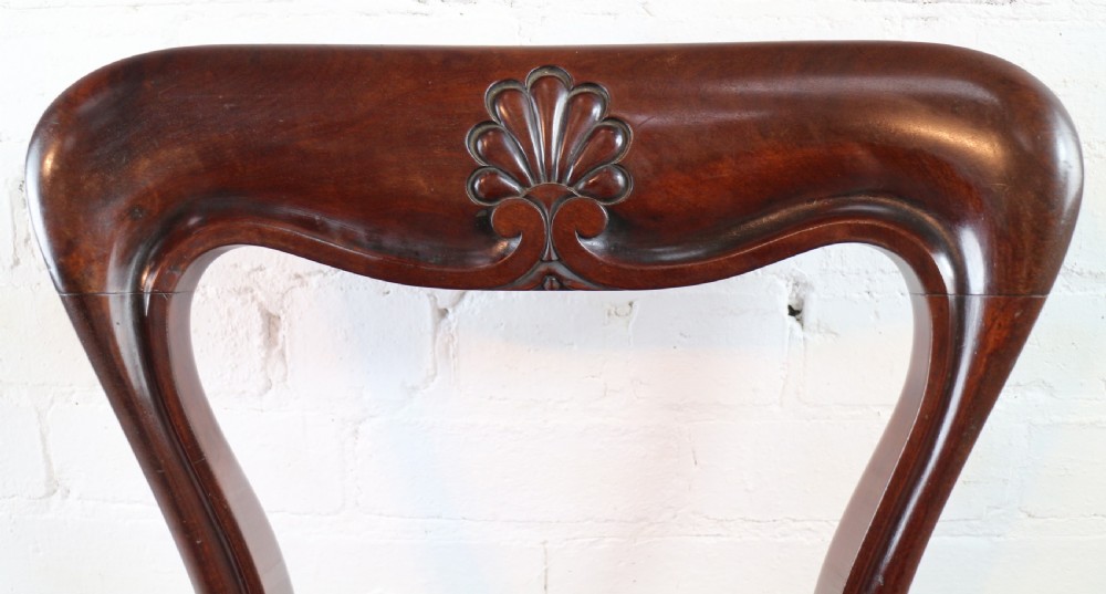 A set of ten William IV mahogany dining chairs with carved top rails, turned front legs, and deep red upholstery. View XIII