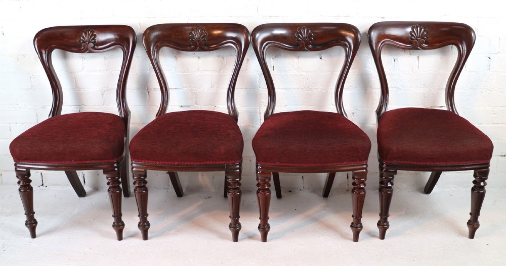 A set of ten William IV mahogany dining chairs with carved top rails, turned front legs, and deep red upholstery. View XIV