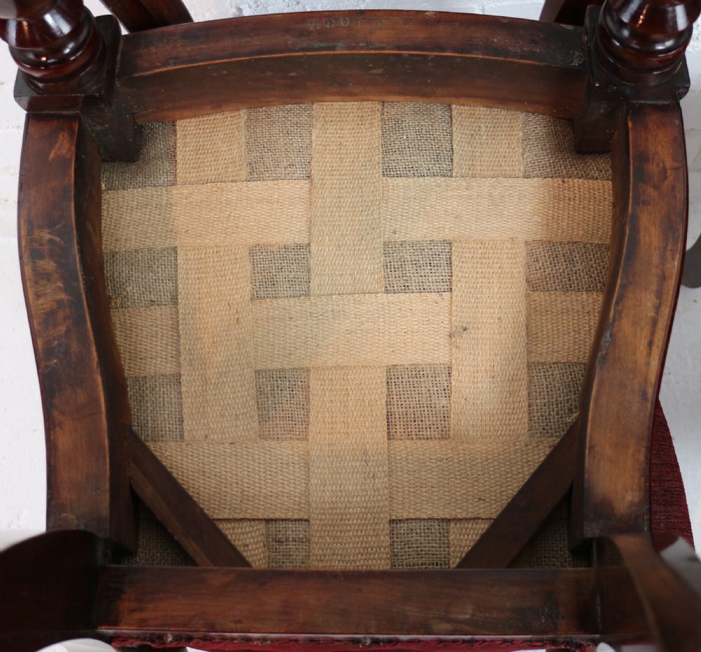 A set of ten William IV mahogany dining chairs with carved top rails, turned front legs, and deep red upholstery. View XVII
