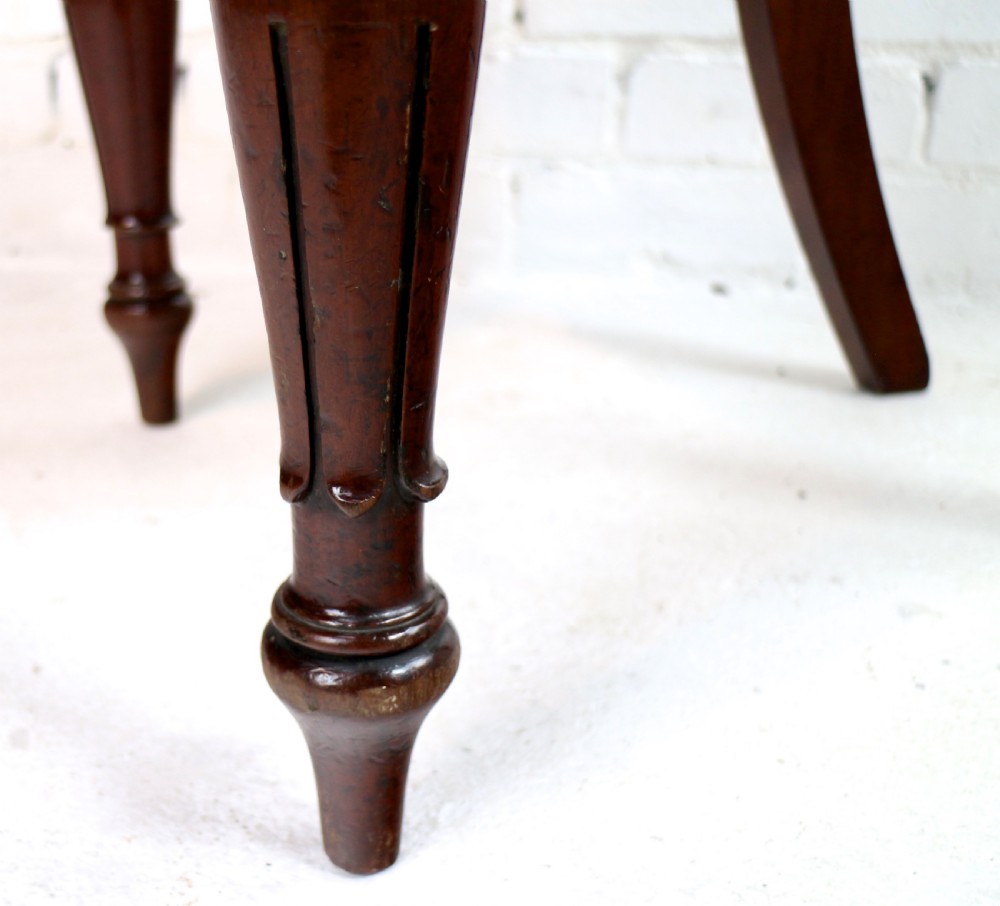 A set of ten William IV mahogany dining chairs with carved top rails, turned front legs, and deep red upholstery. View XVIII