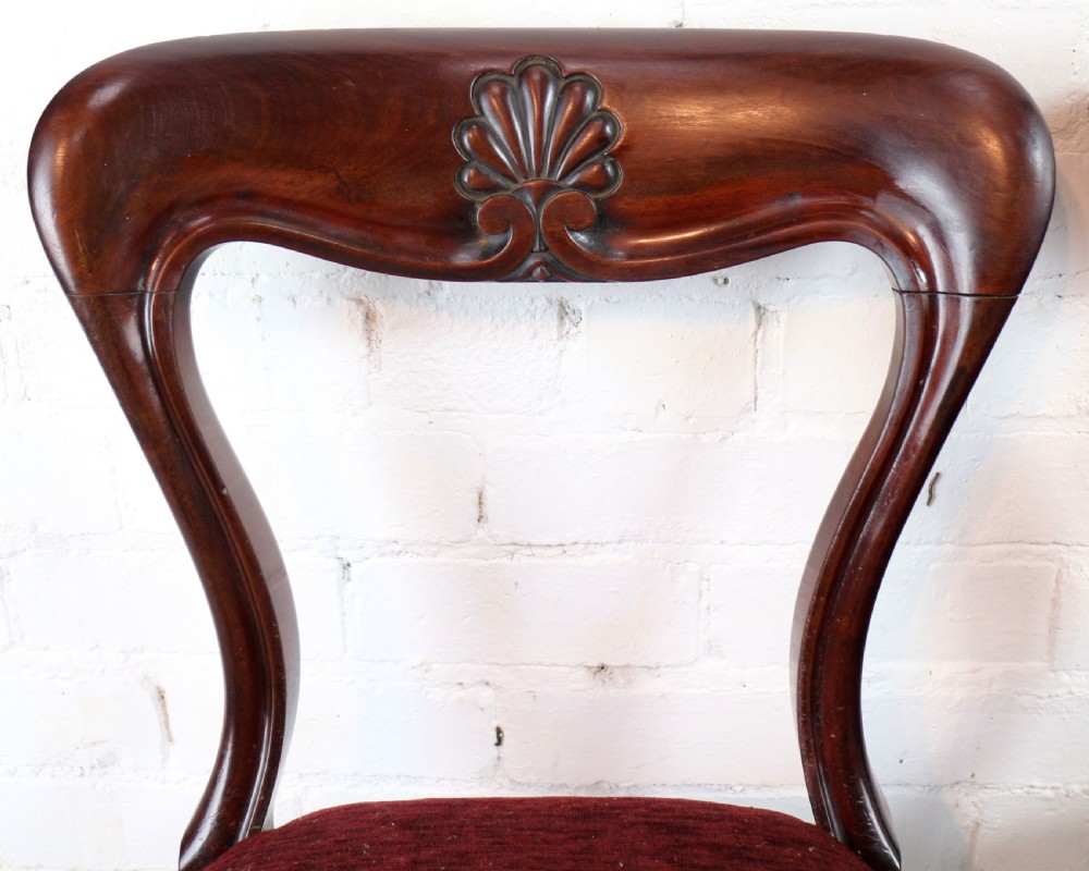 A set of ten William IV mahogany dining chairs with carved top rails, turned front legs, and deep red upholstery. View XIX