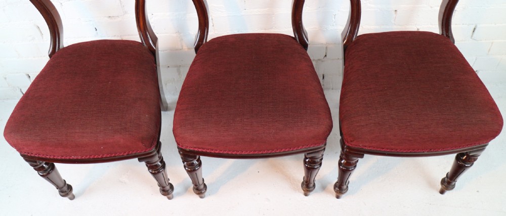 A set of ten William IV mahogany dining chairs with carved top rails, turned front legs, and deep red upholstery. View XXIV