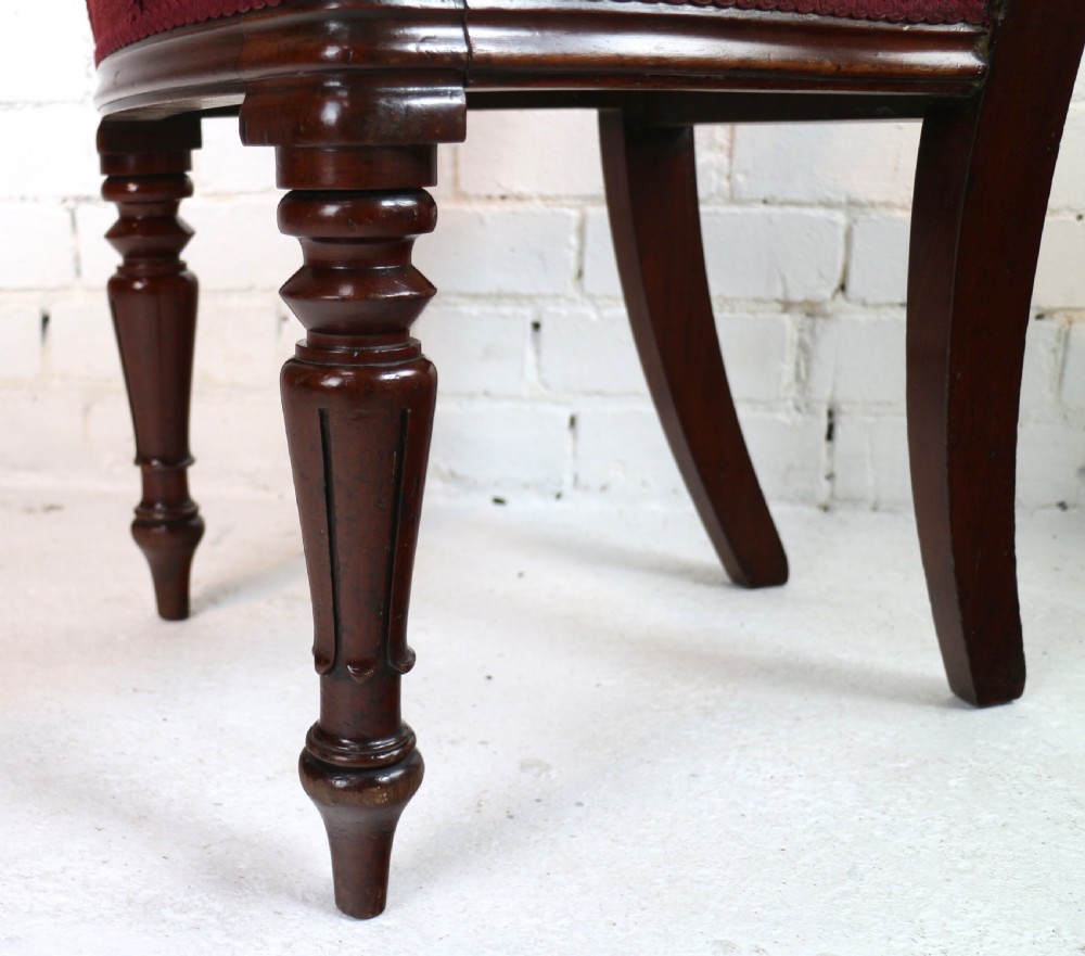 A set of ten William IV mahogany dining chairs with carved top rails, turned front legs, and deep red upholstery. View XXX