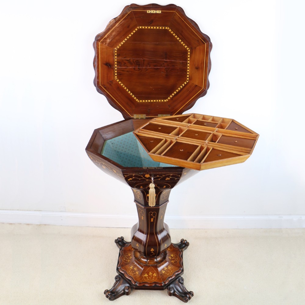 A Victorian Killarney Ware arbutus wood work table with a hinged scalloped top featuring shamrock marquetry on a faceted trumpet pedestal. View VI