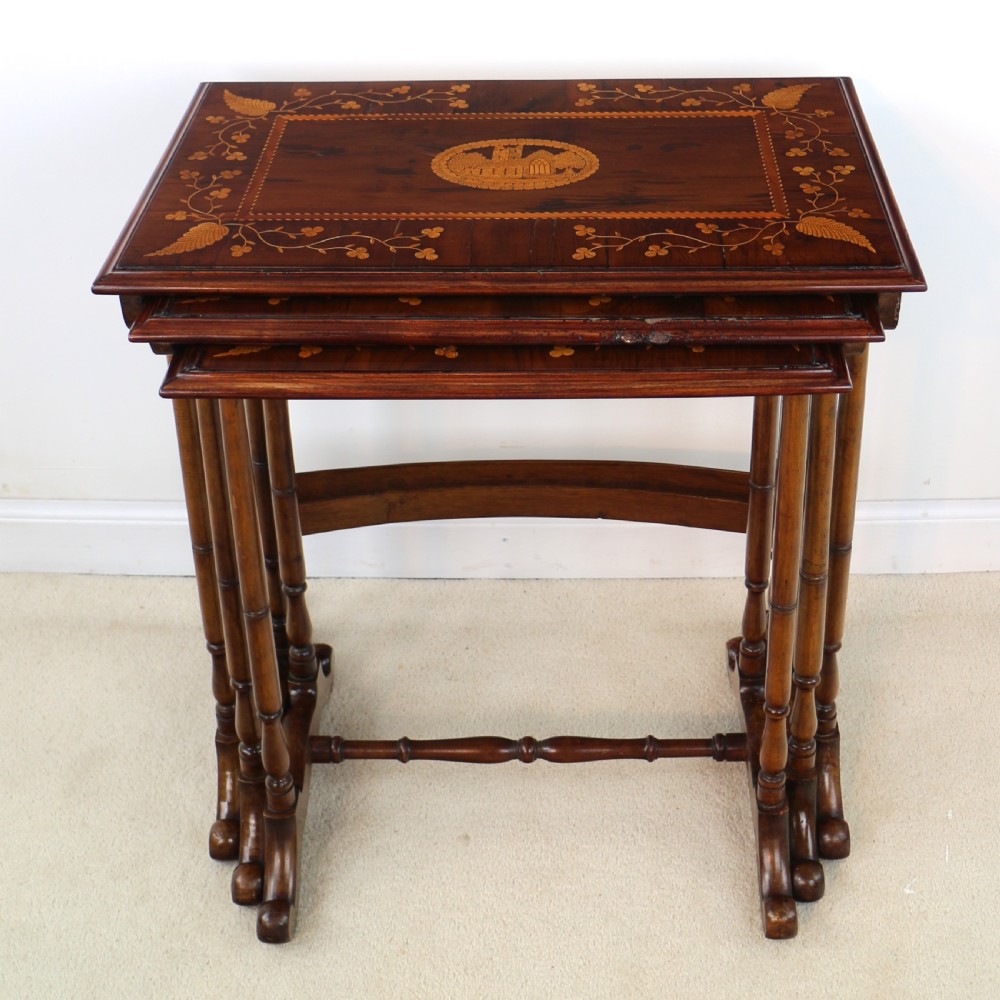 A set of three nested wooden side tables featuring detailed marquetry inlays of foliage and central vignettes, supported by slender turned legs and scroll feet. View VI