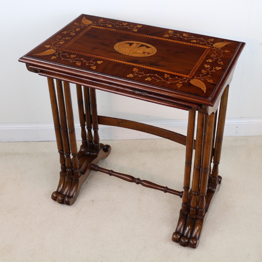 A set of three nested wooden side tables featuring detailed marquetry inlays of foliage and central vignettes, supported by slender turned legs and scroll feet. View VIII