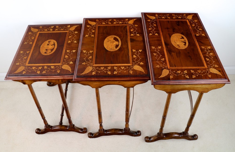 A set of three nested wooden side tables featuring detailed marquetry inlays of foliage and central vignettes, supported by slender turned legs and scroll feet. View XIII
