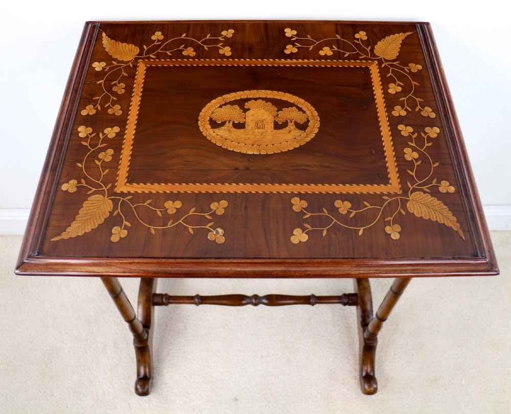 A set of three nested wooden side tables featuring detailed marquetry inlays of foliage and central vignettes, supported by slender turned legs and scroll feet. View XVI