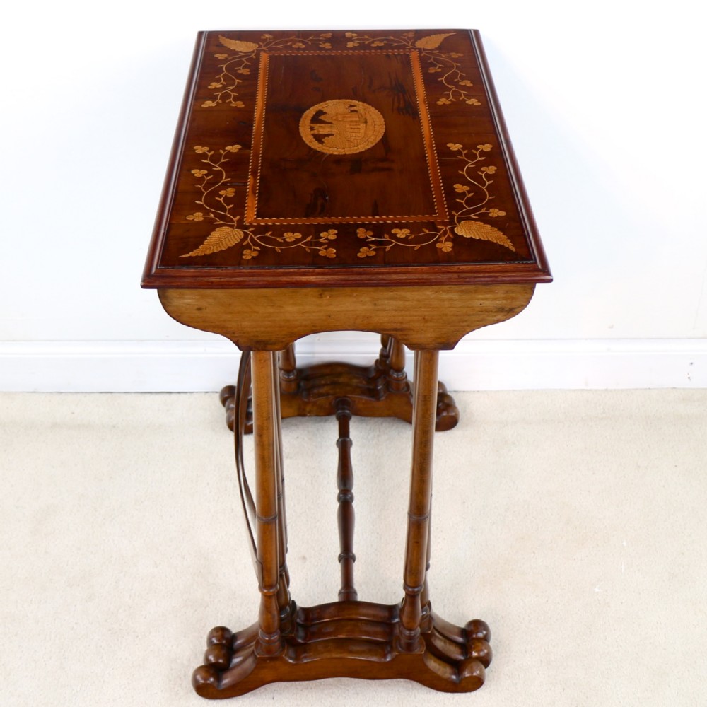 A set of three nested wooden side tables featuring detailed marquetry inlays of foliage and central vignettes, supported by slender turned legs and scroll feet. View XX