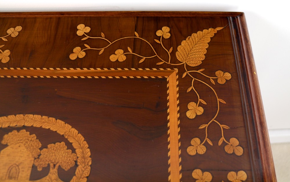 A set of three nested wooden side tables featuring detailed marquetry inlays of foliage and central vignettes, supported by slender turned legs and scroll feet. View XXX