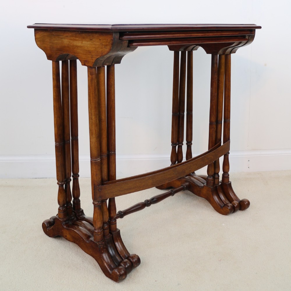 A set of three nested wooden side tables featuring detailed marquetry inlays of foliage and central vignettes, supported by slender turned legs and scroll feet. View XXXI