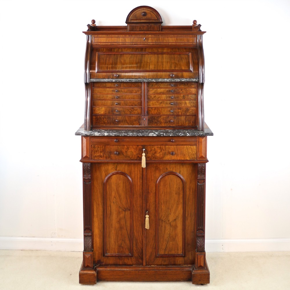 A 19th-century Victorian burr walnut dentist cabinet with a roll-top upper section, shallow drawers, grey marble work surface, and lower two-door cupboard.