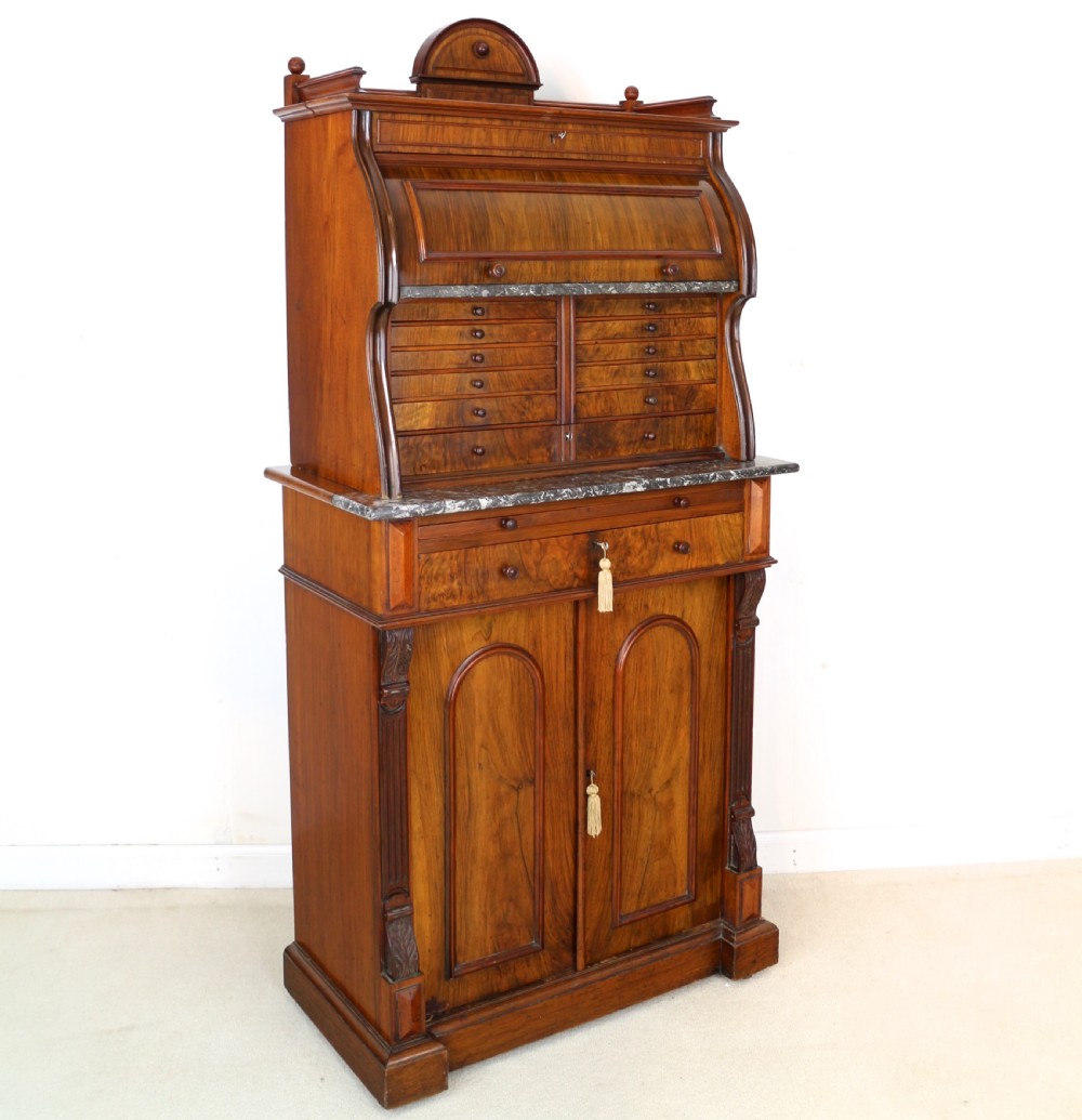 A 19th-century Victorian burr walnut dentist cabinet with a roll-top upper section, shallow drawers, grey marble work surface, and lower two-door cupboard. View II