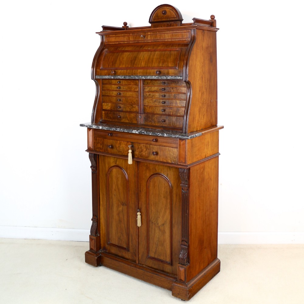 A 19th-century Victorian burr walnut dentist cabinet with a roll-top upper section, shallow drawers, grey marble work surface, and lower two-door cupboard. View III