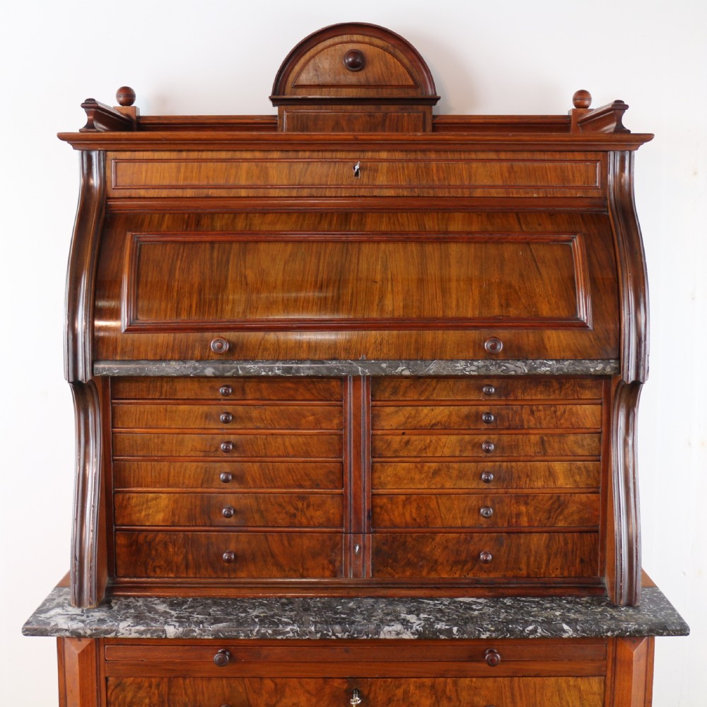 A 19th-century Victorian burr walnut dentist cabinet with a roll-top upper section, shallow drawers, grey marble work surface, and lower two-door cupboard. View VI