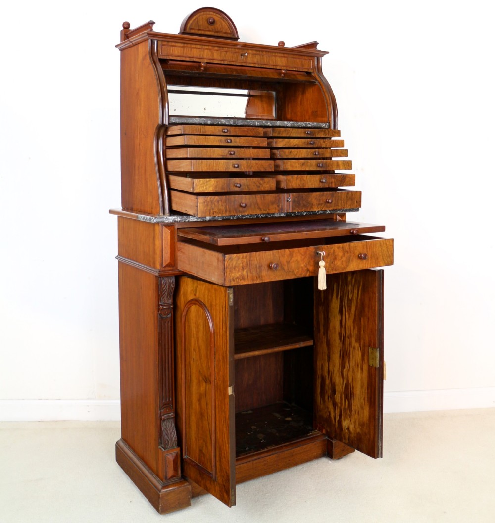 A 19th-century Victorian burr walnut dentist cabinet with a roll-top upper section, shallow drawers, grey marble work surface, and lower two-door cupboard. View XXI