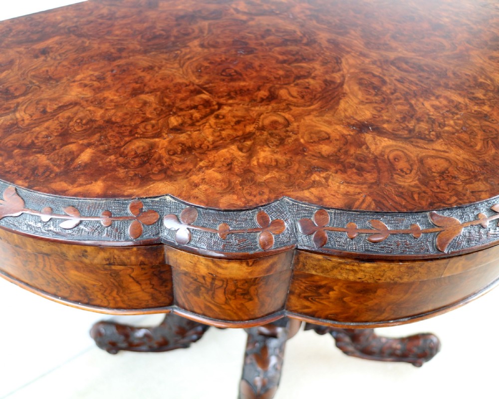 A pair of Victorian burr walnut fold-over card tables featuring shaped demi-lune tops, carved aprons, central turned pedestals, and carved quadform legs with castors. View XXIV